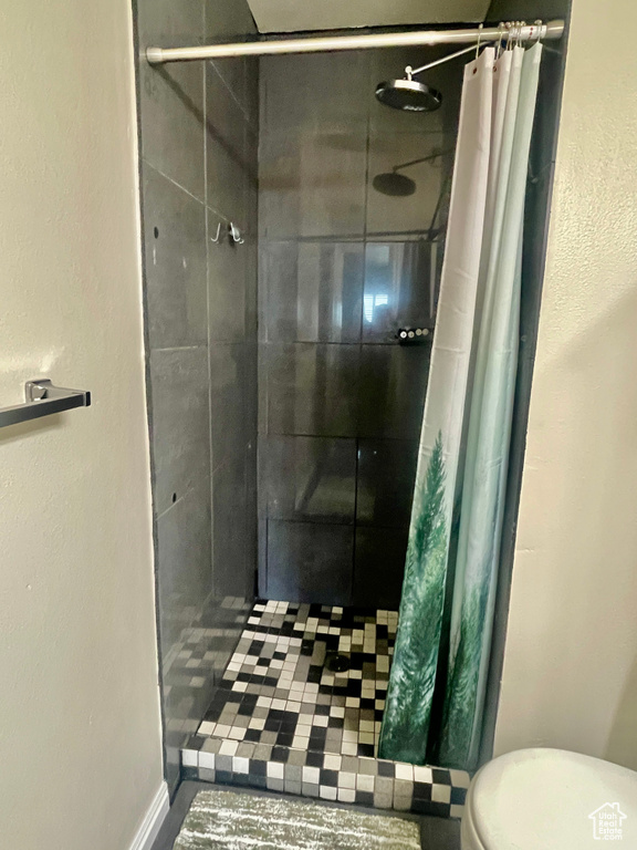 Full bath with toilet and a shower stall