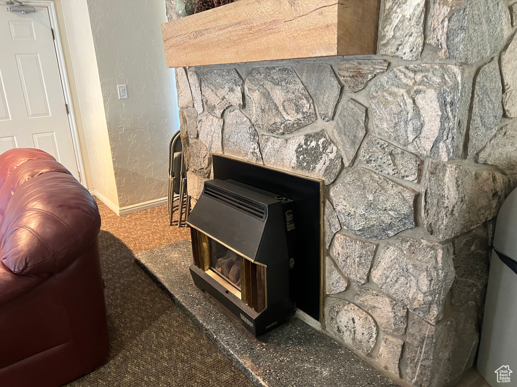 Details with a textured wall, baseboards, and a wood stove