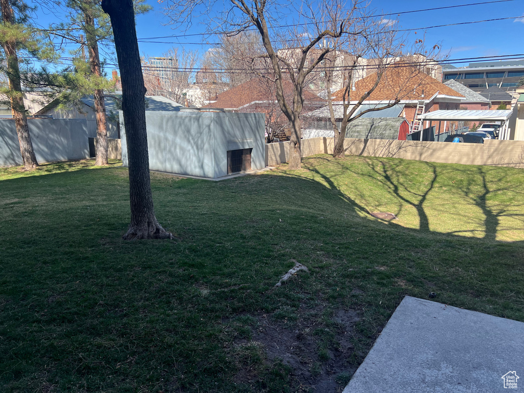 View of yard with an outdoor structure and fence