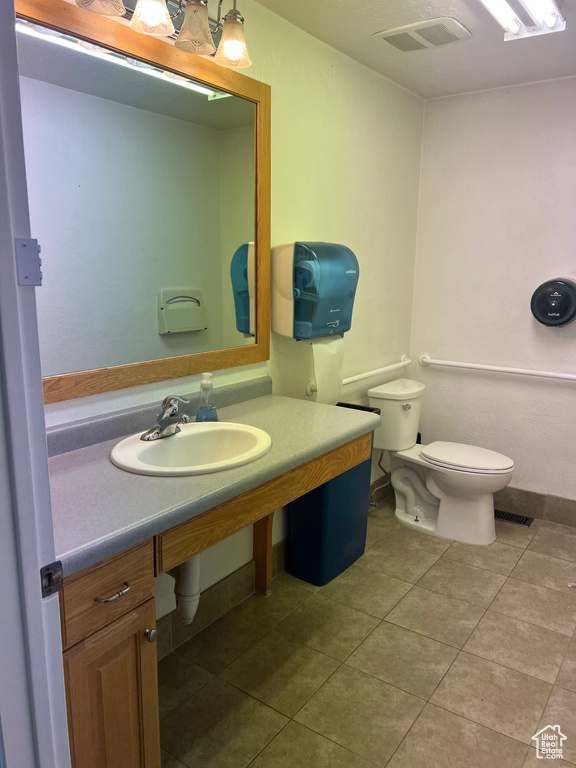 Bathroom featuring tile patterned floors, toilet, and a sink
