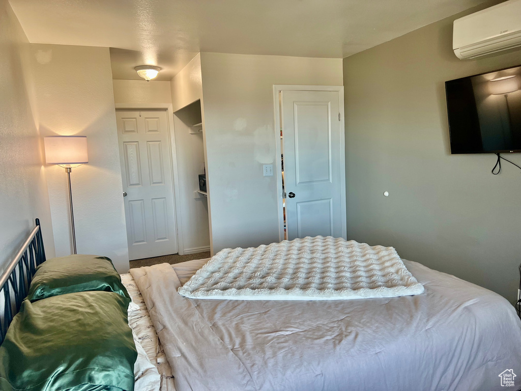 Bedroom with an AC wall unit and a closet