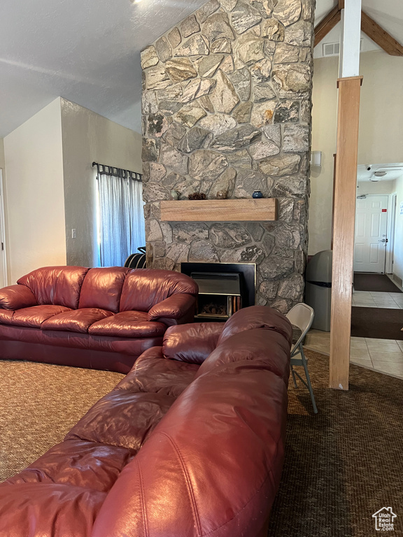 Tiled living room featuring a fireplace, carpet floors, vaulted ceiling, and visible vents