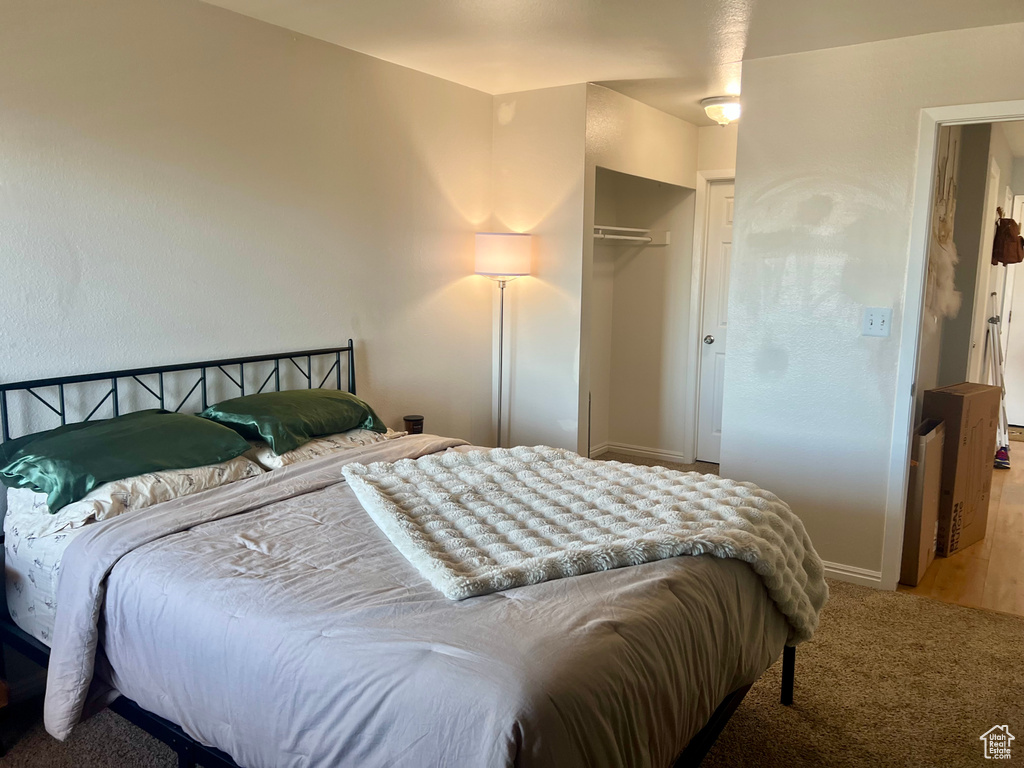 Carpeted bedroom featuring a closet and baseboards