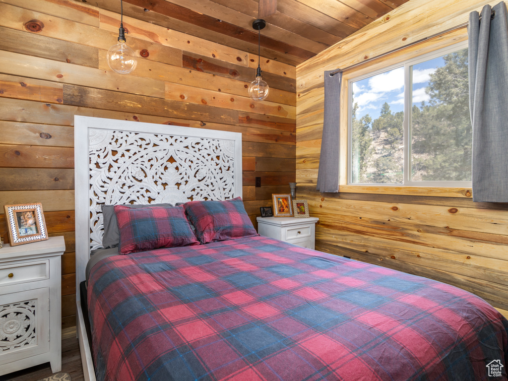 Bedroom with wooden ceiling and wood walls