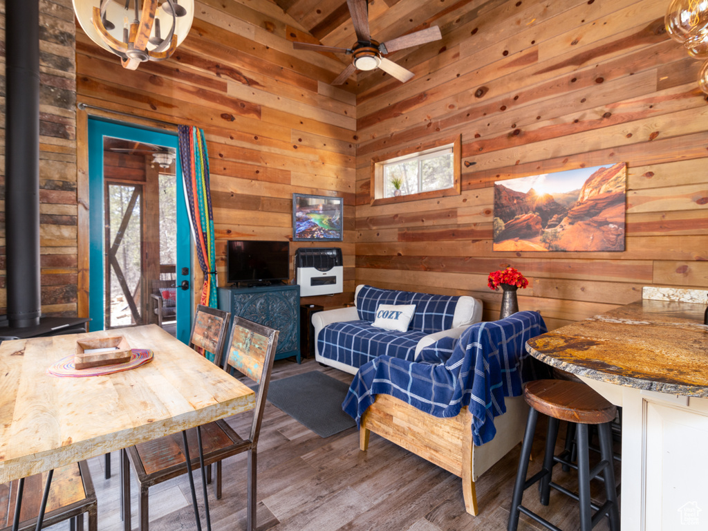 Living area featuring wood walls, ceiling fan, and wood finished floors