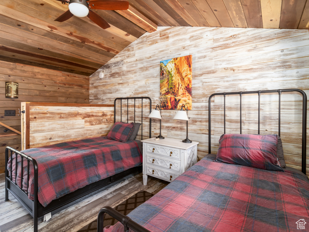 Bedroom featuring wood ceiling, wood walls, and lofted ceiling