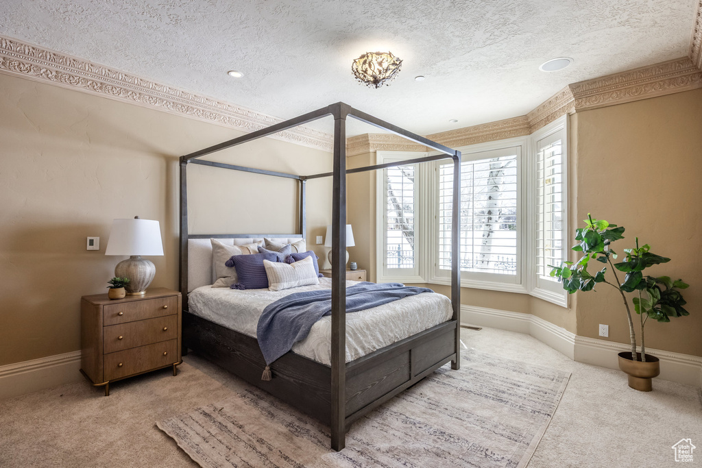 Carpeted bedroom featuring baseboards and a textured ceiling