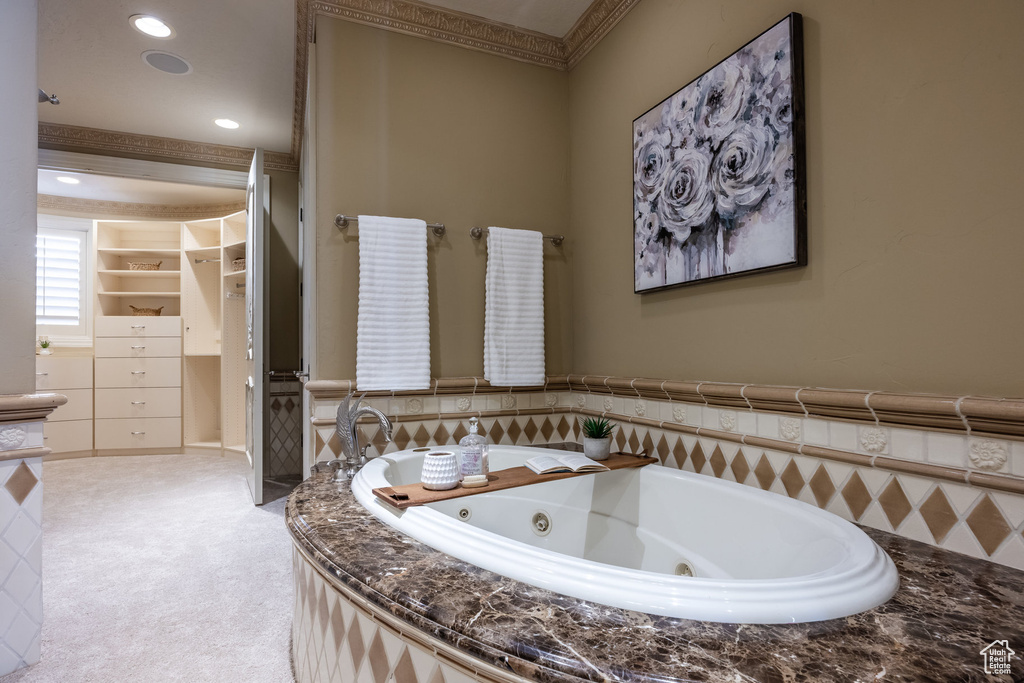 Full bathroom with a jetted tub, recessed lighting, and crown molding