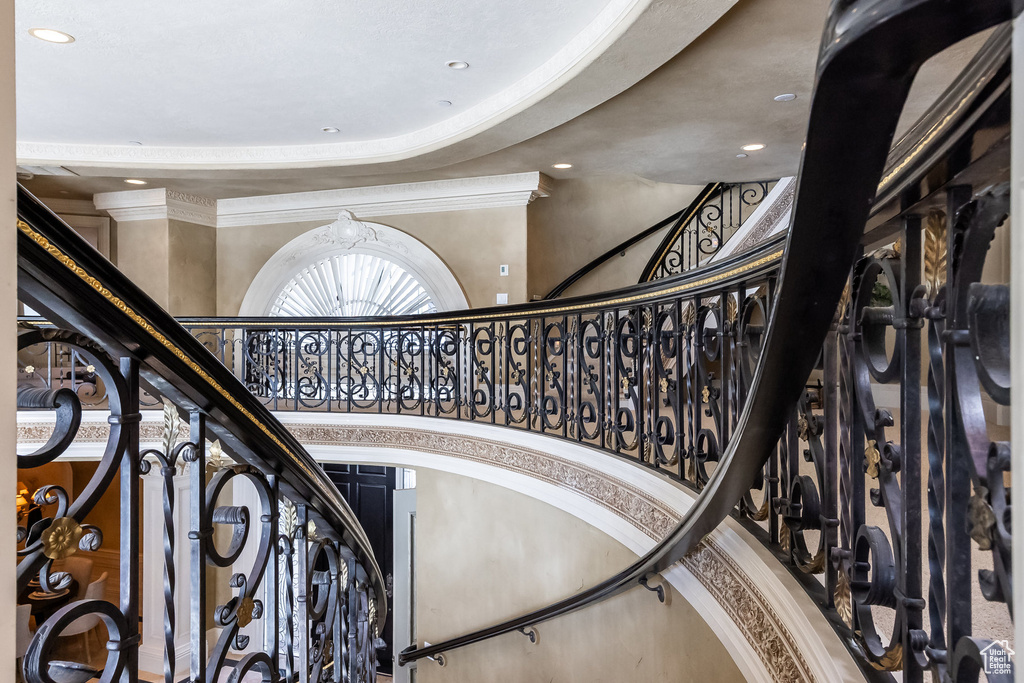 Staircase featuring a high ceiling, ornamental molding, and recessed lighting