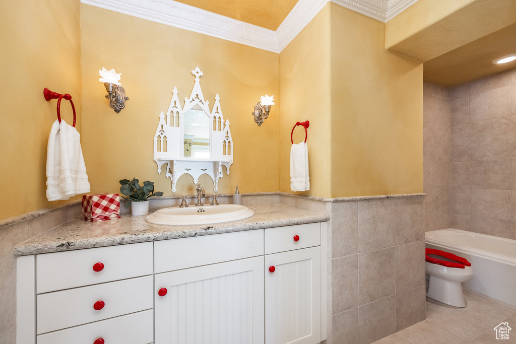 Bathroom featuring tile patterned flooring, vanity, crown molding, and tile walls