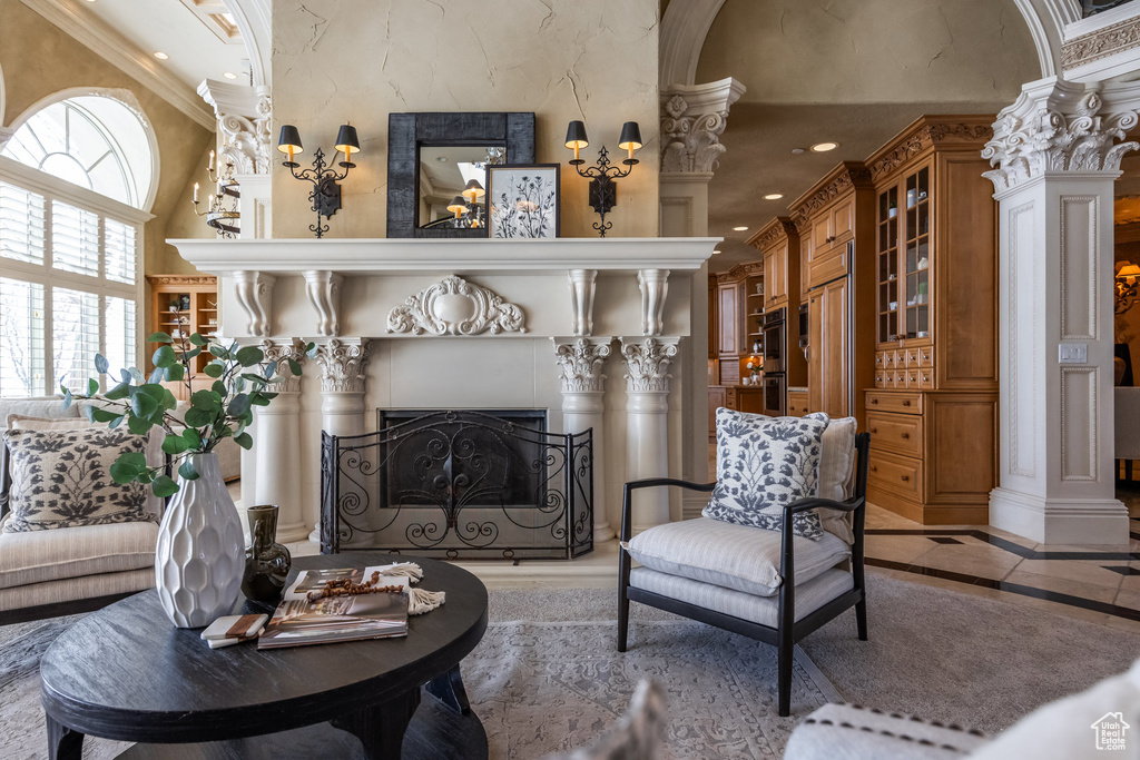 Living area featuring ornamental molding, a high end fireplace, recessed lighting, and decorative columns