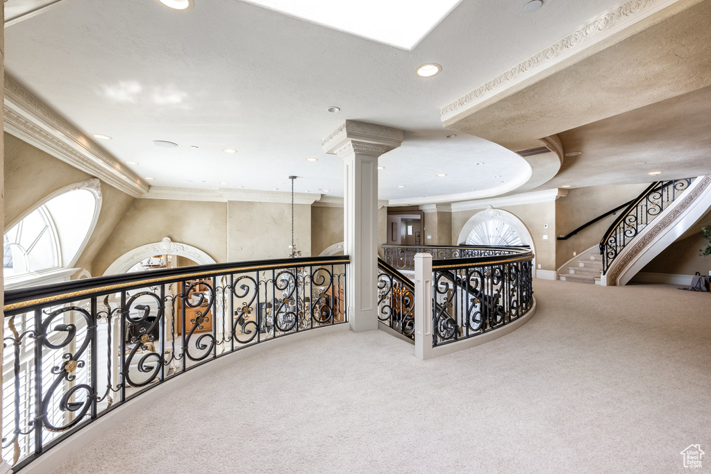 Corridor featuring carpet flooring, recessed lighting, crown molding, and ornate columns