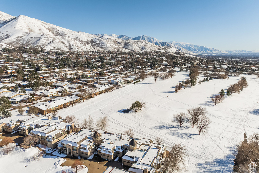 Snowy aerial view featuring a mountain view and a residential view