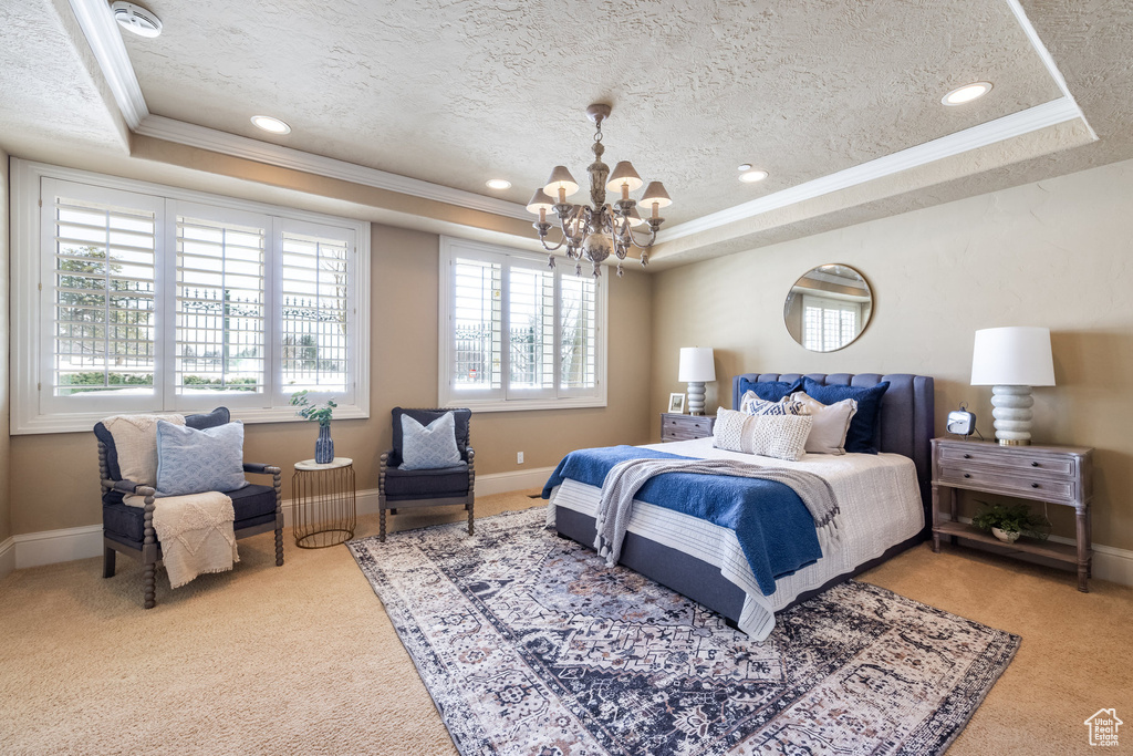 Bedroom featuring crown molding, carpet flooring, a raised ceiling, a textured ceiling, and an inviting chandelier