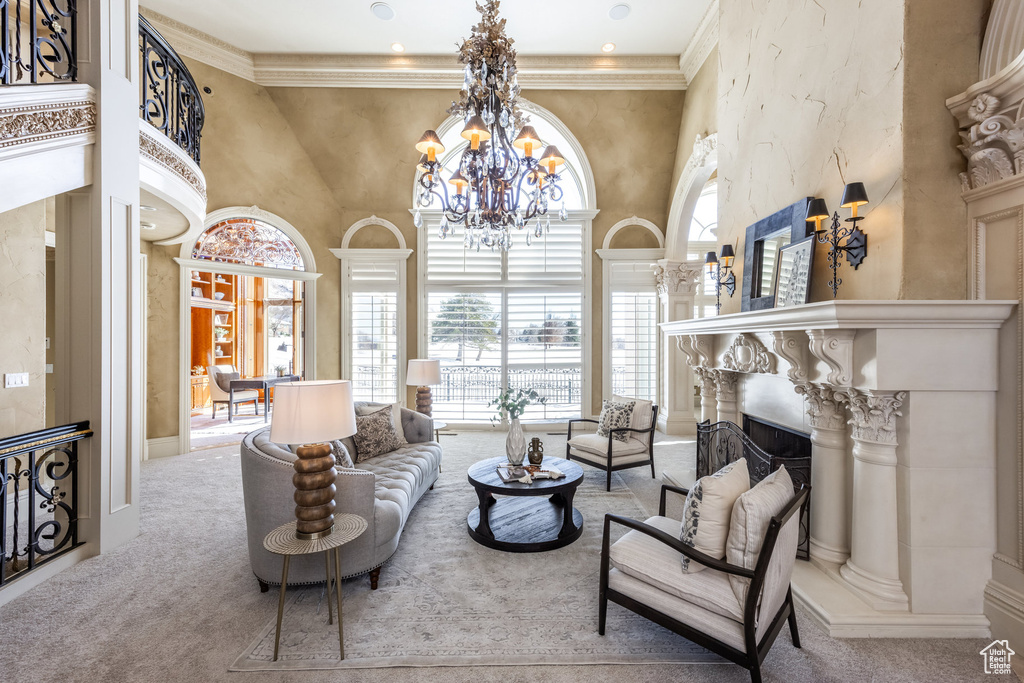 Carpeted living room with crown molding, a towering ceiling, and an inviting chandelier