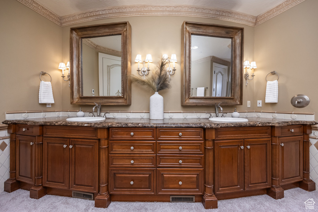 Full bathroom featuring double vanity, a sink, and visible vents