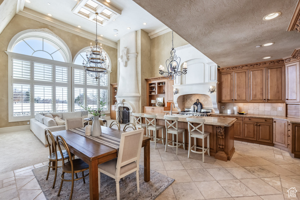 Dining room featuring recessed lighting, an inviting chandelier, ornamental molding, a textured ceiling, and a high ceiling