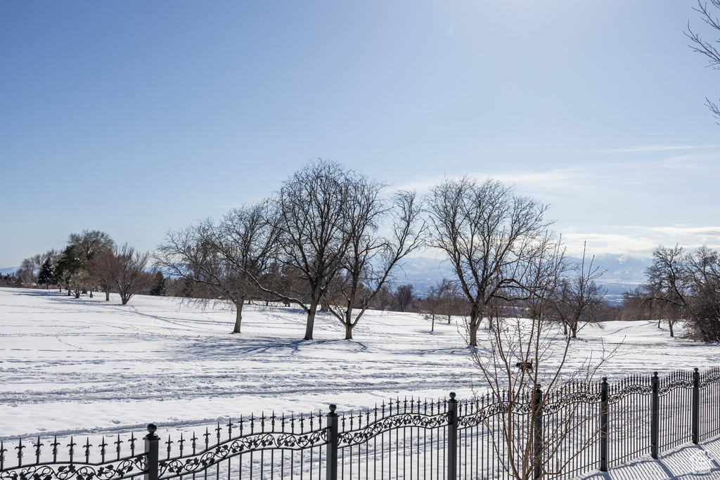 Yard layered in snow featuring fence