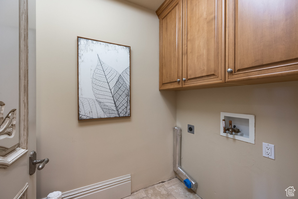 Laundry room with hookup for an electric dryer, cabinet space, and hookup for a washing machine