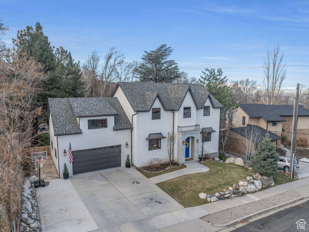 View of front of home with stucco siding, driveway, and a front lawn