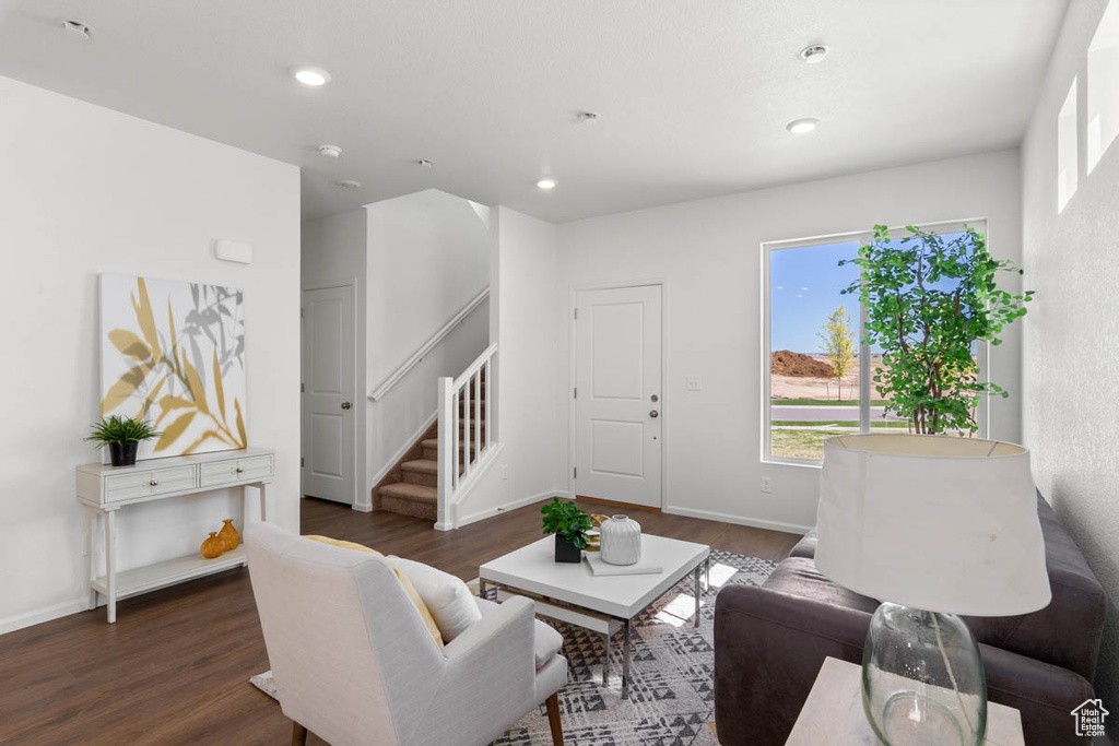 Living area with stairs, wood finished floors, baseboards, and recessed lighting