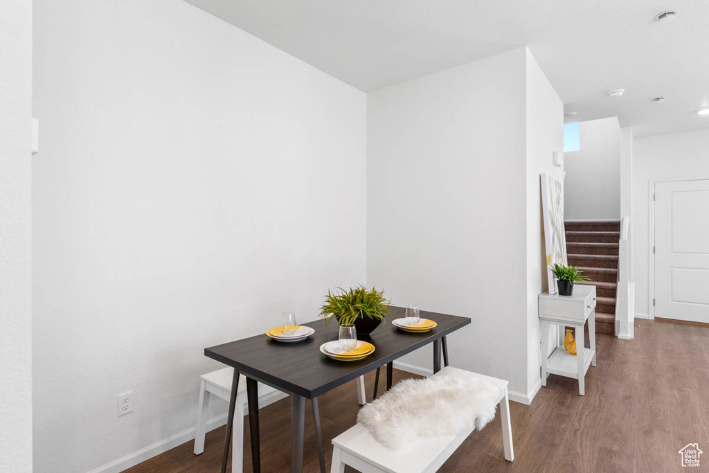 Dining space featuring baseboards, wood finished floors, and stairway