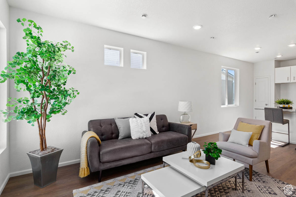 Living room featuring dark wood-style floors, baseboards, and recessed lighting
