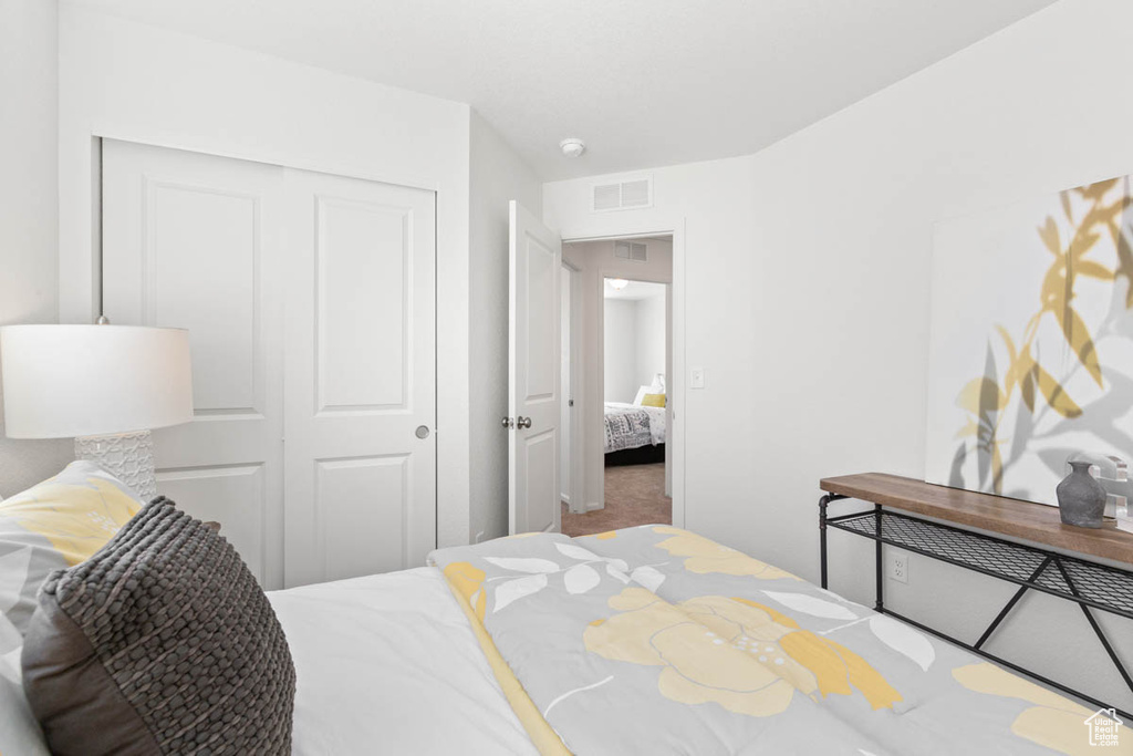 Carpeted bedroom with a closet and visible vents
