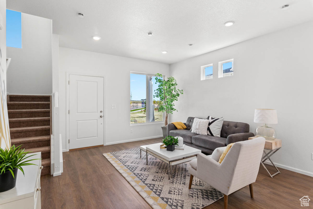 Living area featuring stairs, recessed lighting, baseboards, and dark wood-type flooring