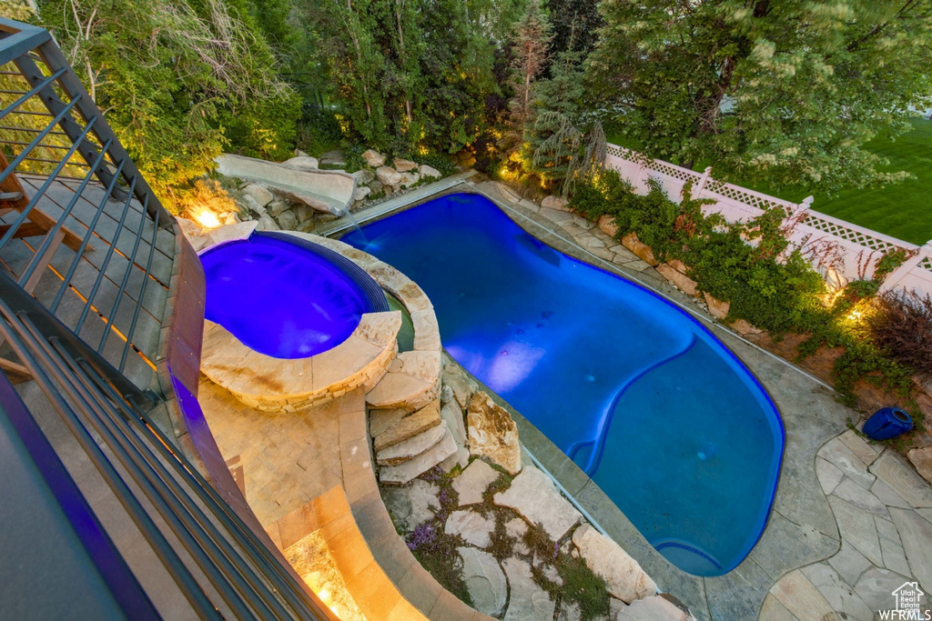Outdoor pool with a fenced backyard and an in ground hot tub