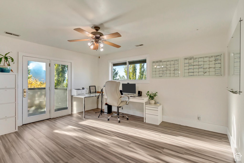 Office area with baseboards, visible vents, wood finished floors, and ceiling fan