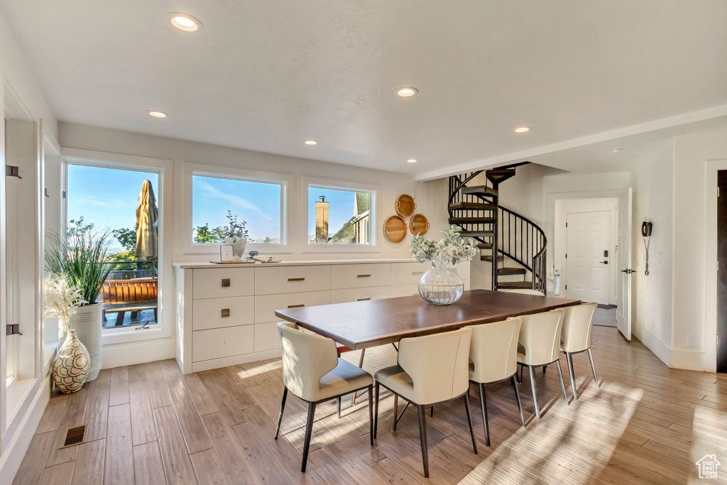 Dining room featuring a wealth of natural light, light wood-style flooring, and stairway