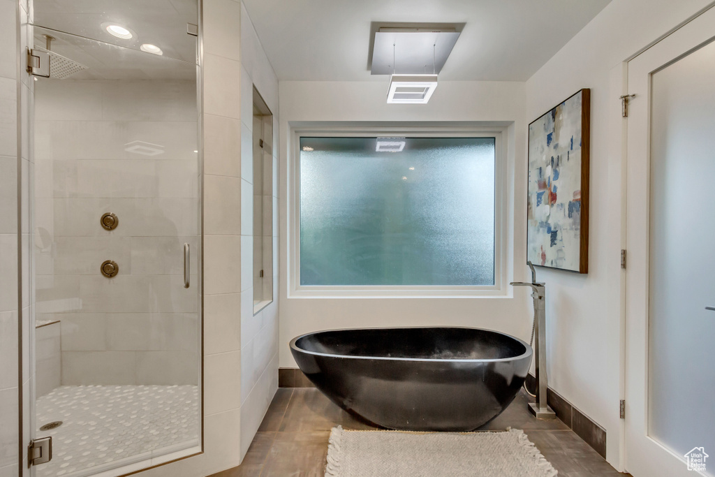 Full bath featuring a stall shower, baseboards, visible vents, and a freestanding tub
