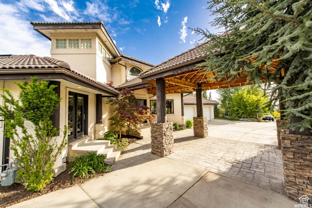View of patio / terrace featuring driveway, a garage, and french doors
