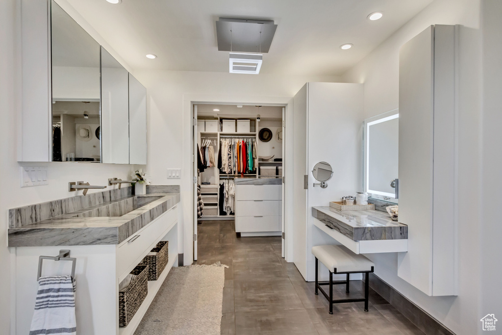 Full bathroom with vanity, a walk in closet, and recessed lighting