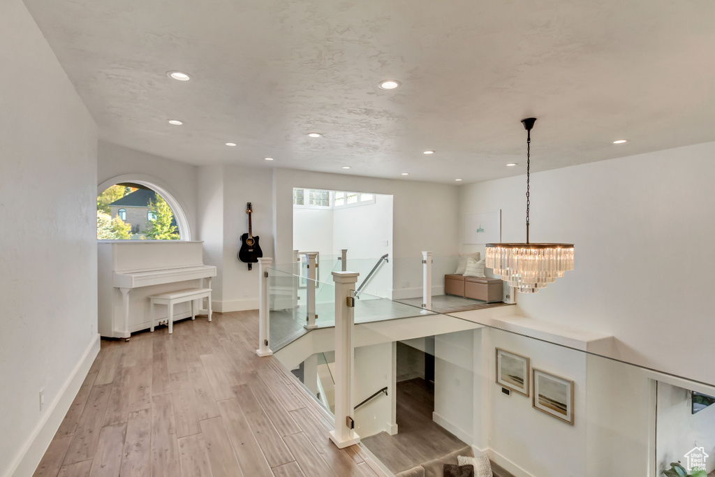 Office space with recessed lighting, a notable chandelier, baseboards, and light wood-type flooring