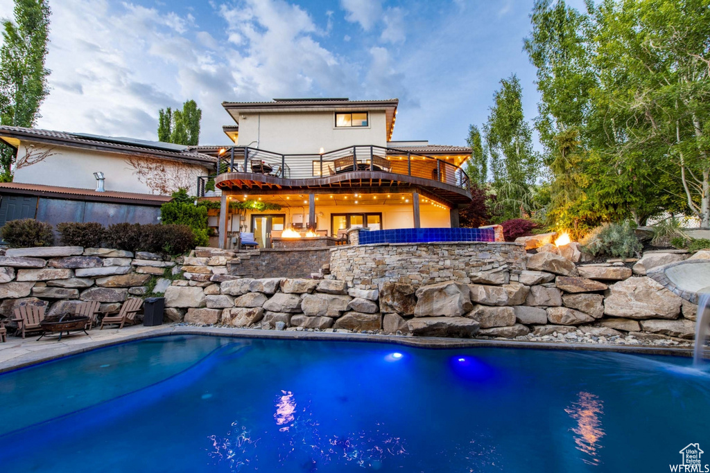 Outdoor pool with an outdoor fire pit and a patio