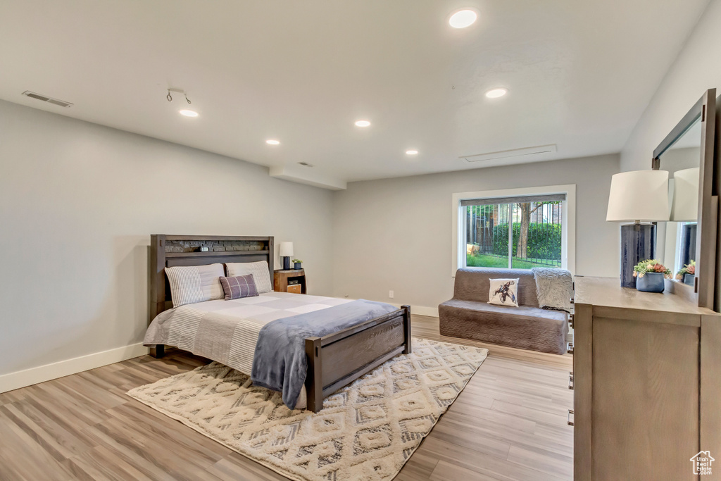 Bedroom with baseboards, visible vents, and light wood-style floors