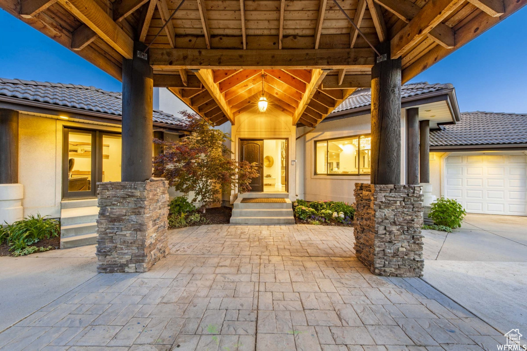 View of patio / terrace featuring an attached garage, a gazebo, and concrete driveway