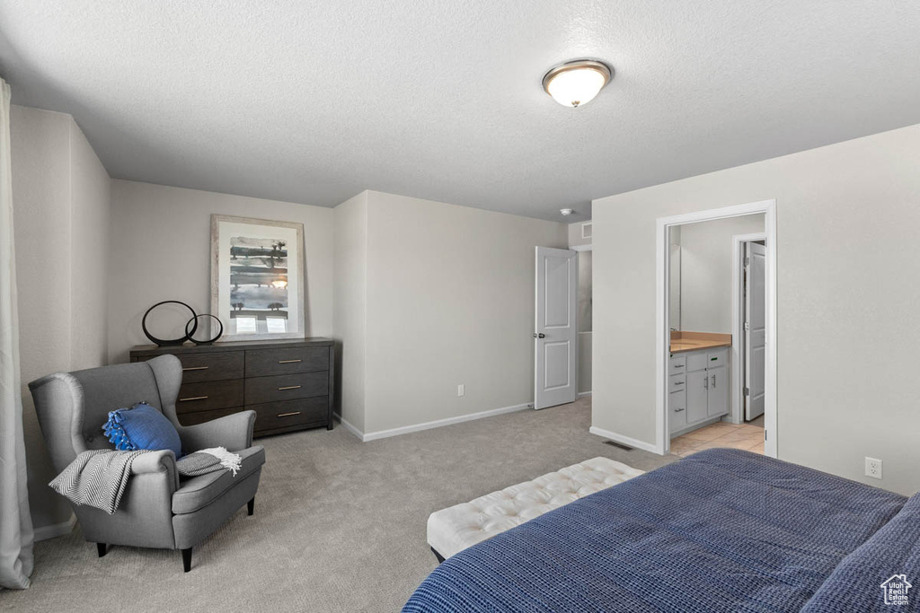 Bedroom with light carpet, baseboards, and a textured ceiling