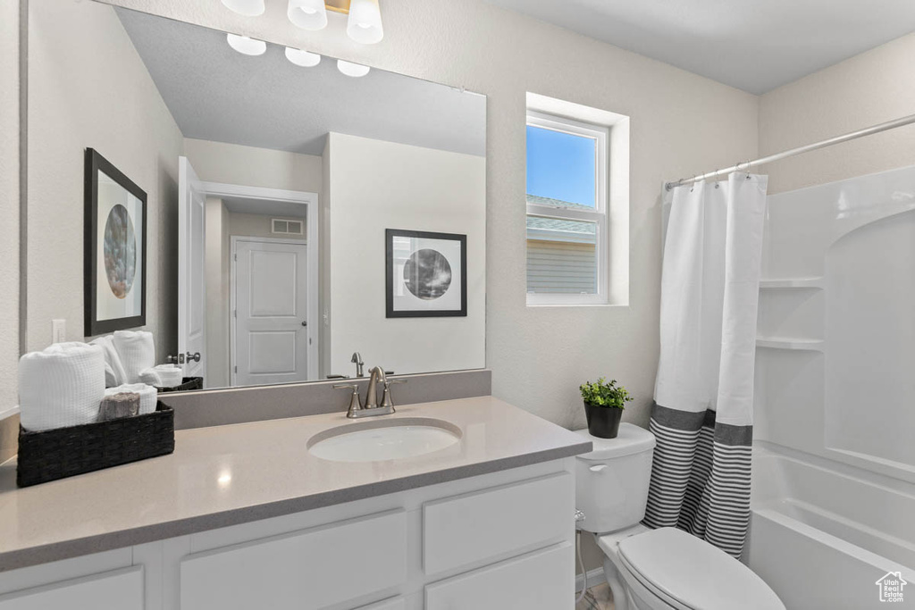 Full bathroom featuring visible vents, toilet, shower / bath combination with curtain, and vanity