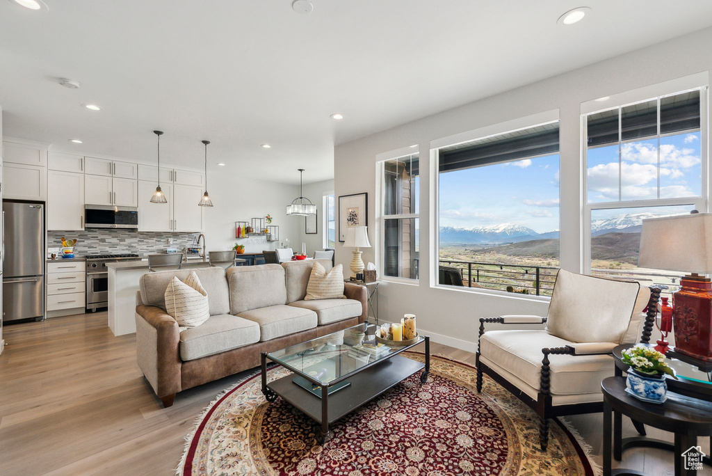 Living area featuring light wood-type flooring, recessed lighting, a mountain view, and baseboards