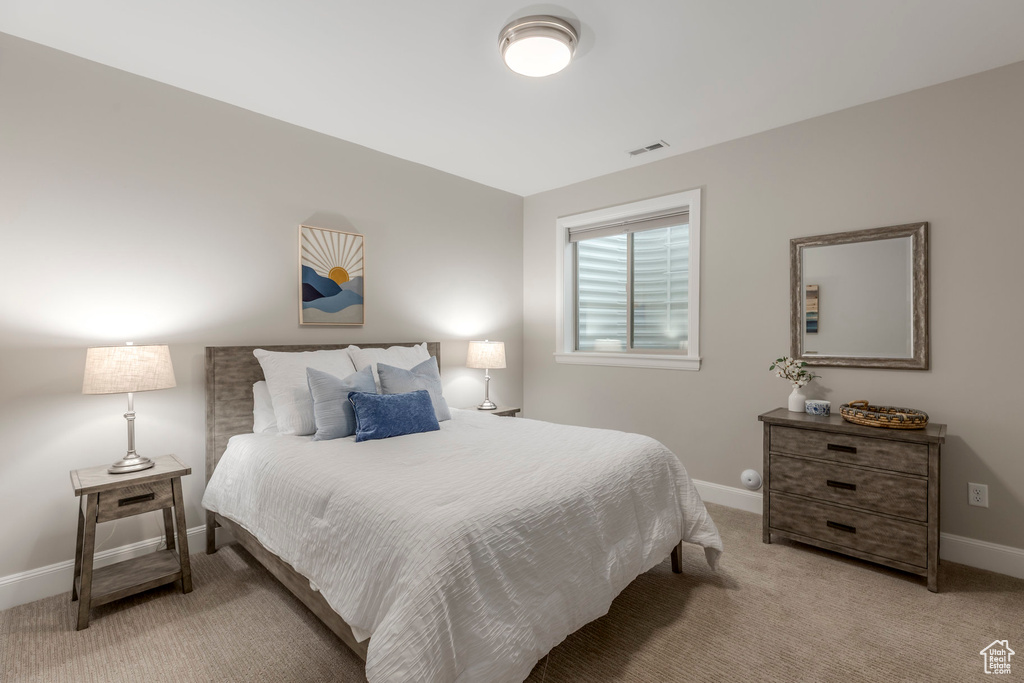 Bedroom featuring light carpet and baseboards