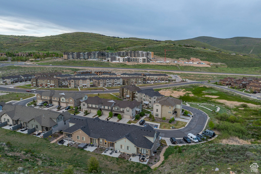 Aerial view of property and surrounding area with a mountainous background and nearby suburban area