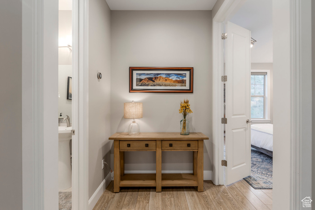 Hallway with light wood-style floors and baseboards