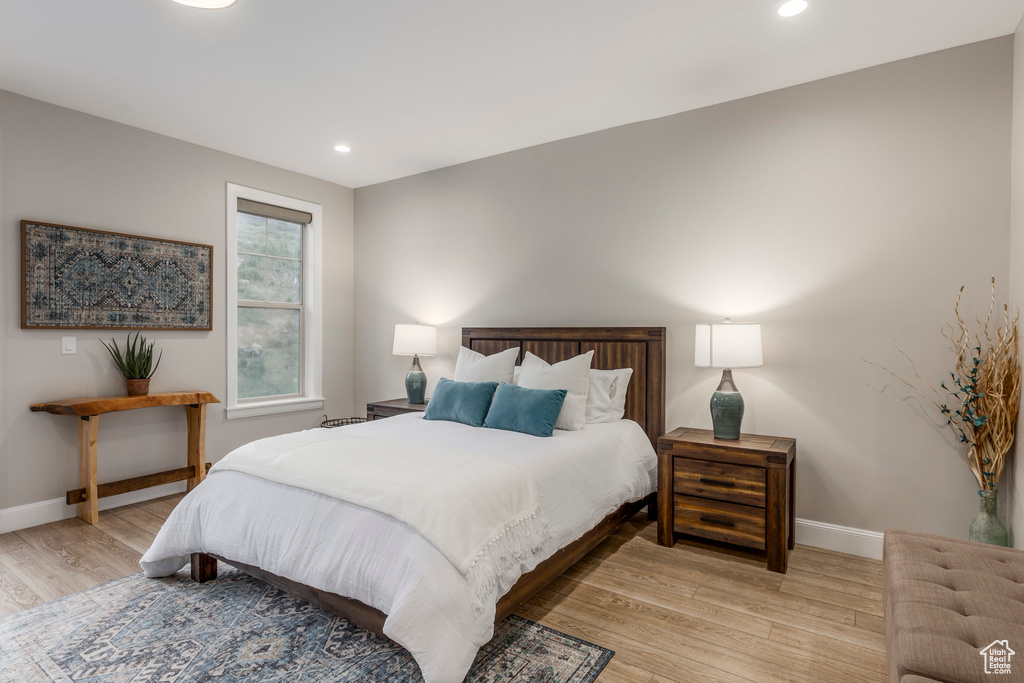 Bedroom with light wood-type flooring, baseboards, and recessed lighting