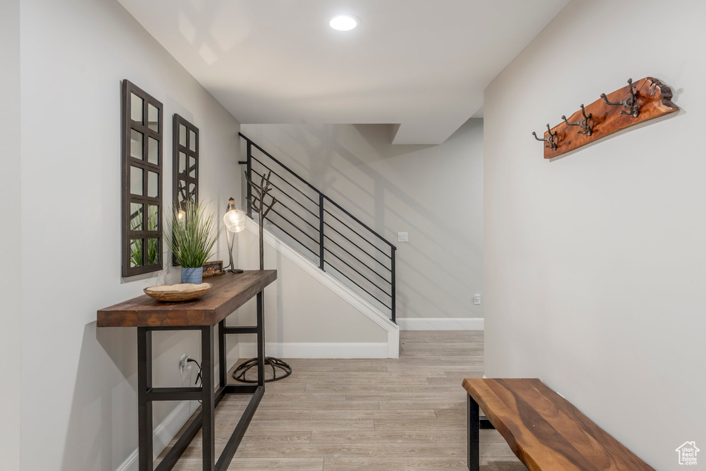 Stairway with wood finished floors, baseboards, and recessed lighting