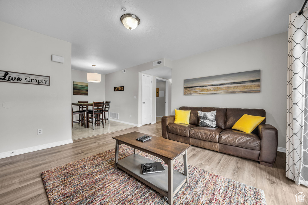 Living area featuring wood finished floors, baseboards, and visible vents