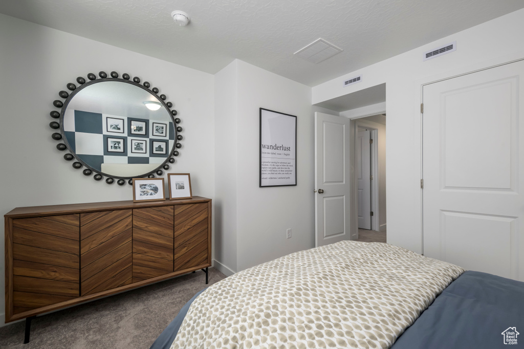 Bedroom with baseboards, carpet floors, a textured ceiling, and visible vents