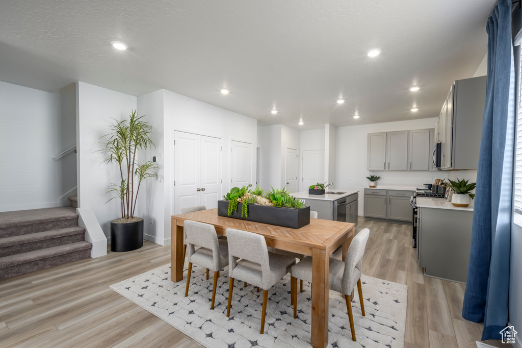 Dining space with baseboards, recessed lighting, light wood-style flooring, and stairway